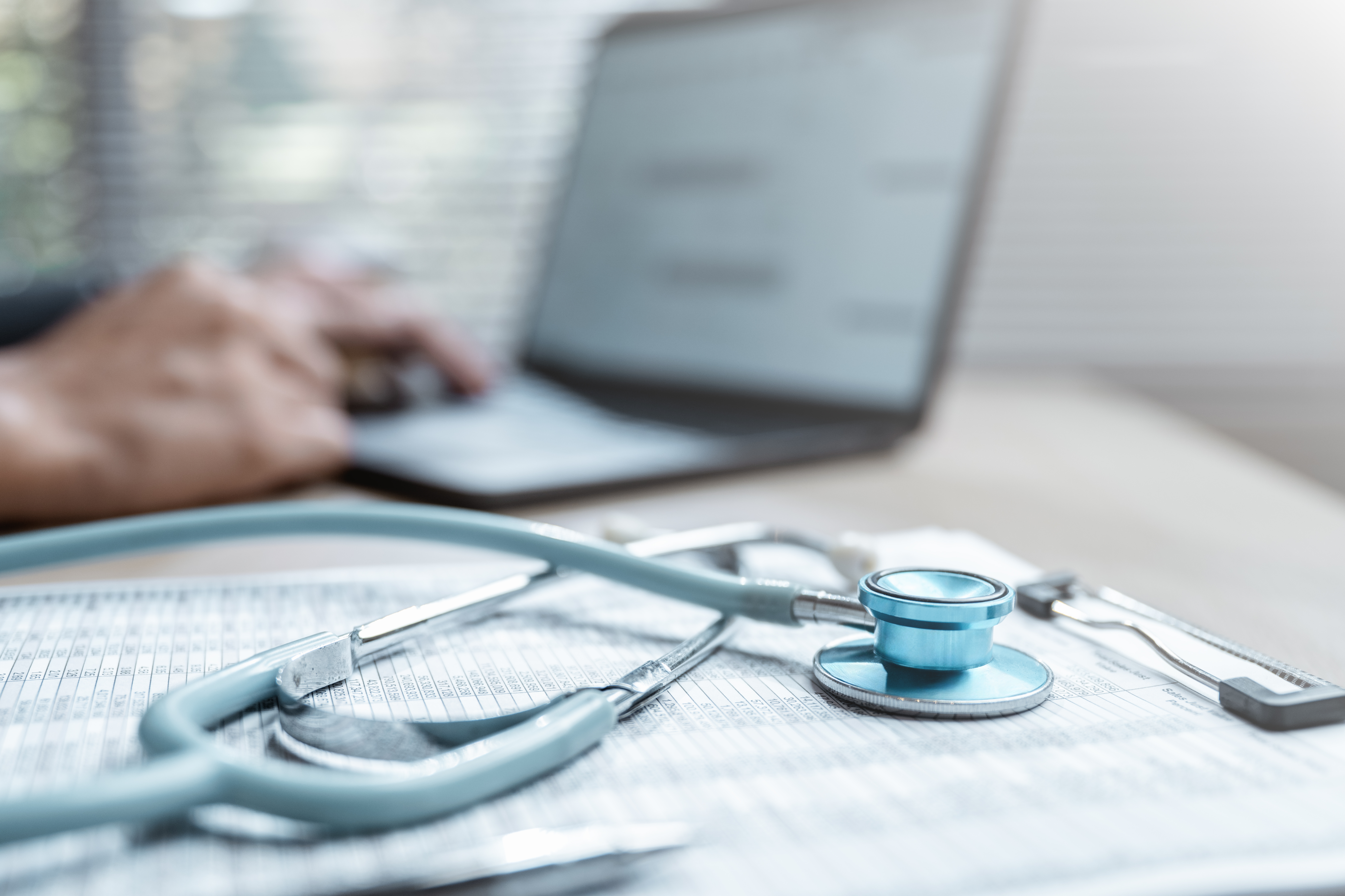 Health insurance concept. Healthcare and medical care. Life insurance policy. Medicine, Hospital, Stethoscope, Doctor. Patient business. Healthcare expense. A person is typing with a stethoscope.